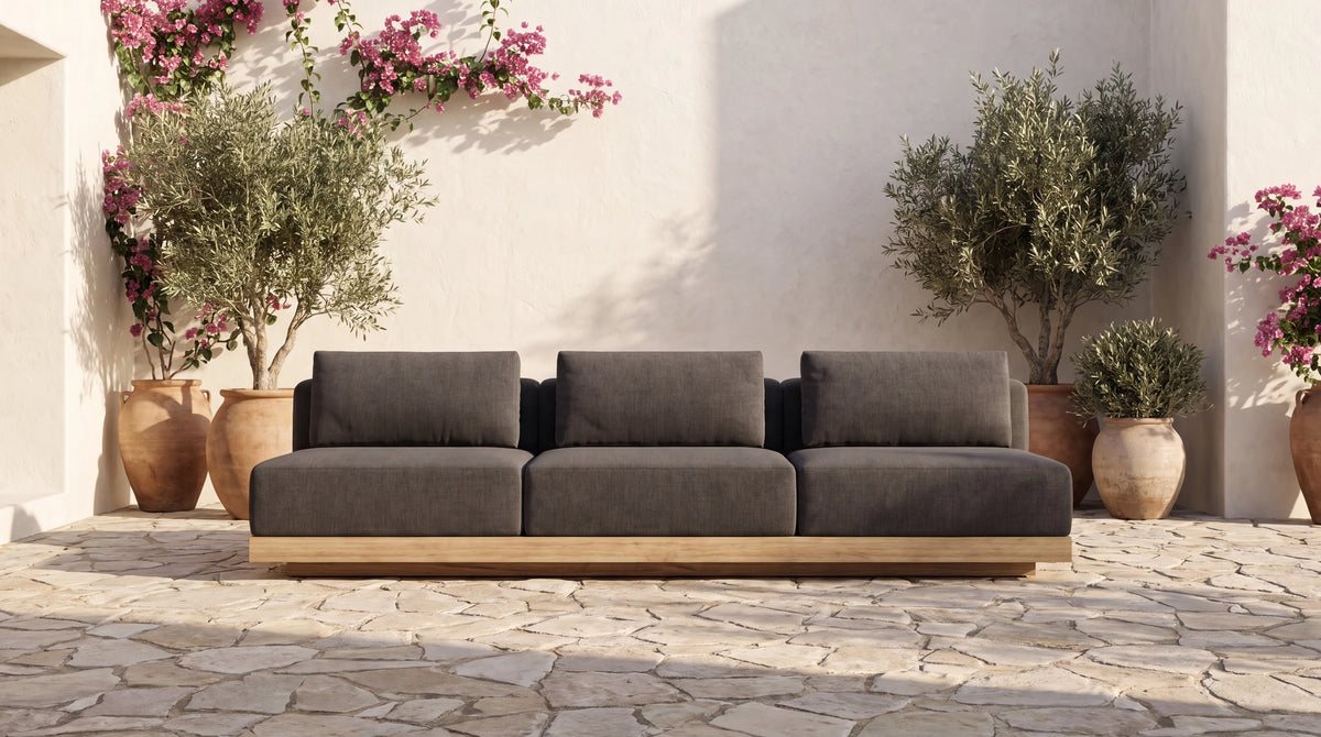 Solis solid teak sofa in a whitewashed Mediterranean courtyard